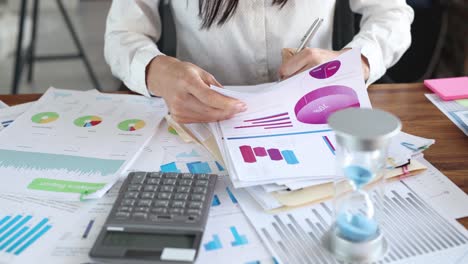 a person analyzing business data and financial reports on an office desk