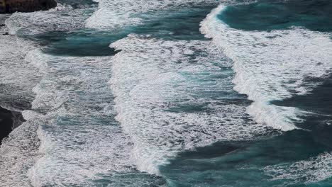 aerial view of waves crashing with white foam and blue color in atlantic ocean in la palma nogales beach canary islands