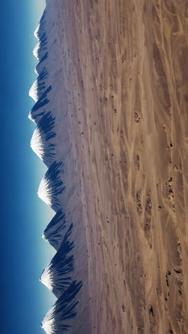 aerial view of snowy mountain range in desert