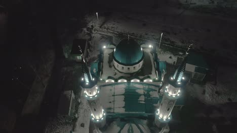 muslim mosque with powerful light equipment on snowy street