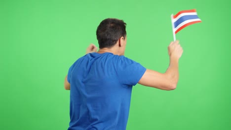 Rear view of a man waving a thai pennant