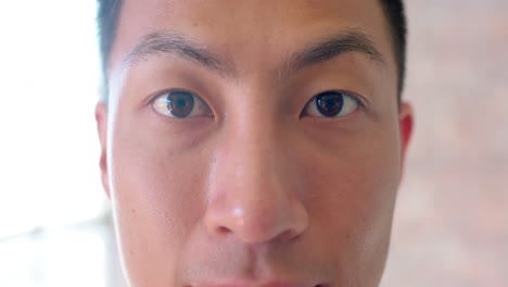 Close-up-portrait-of-asian-creative-businessman-opening-eyes-and-smiling-in-office,-slow-motion