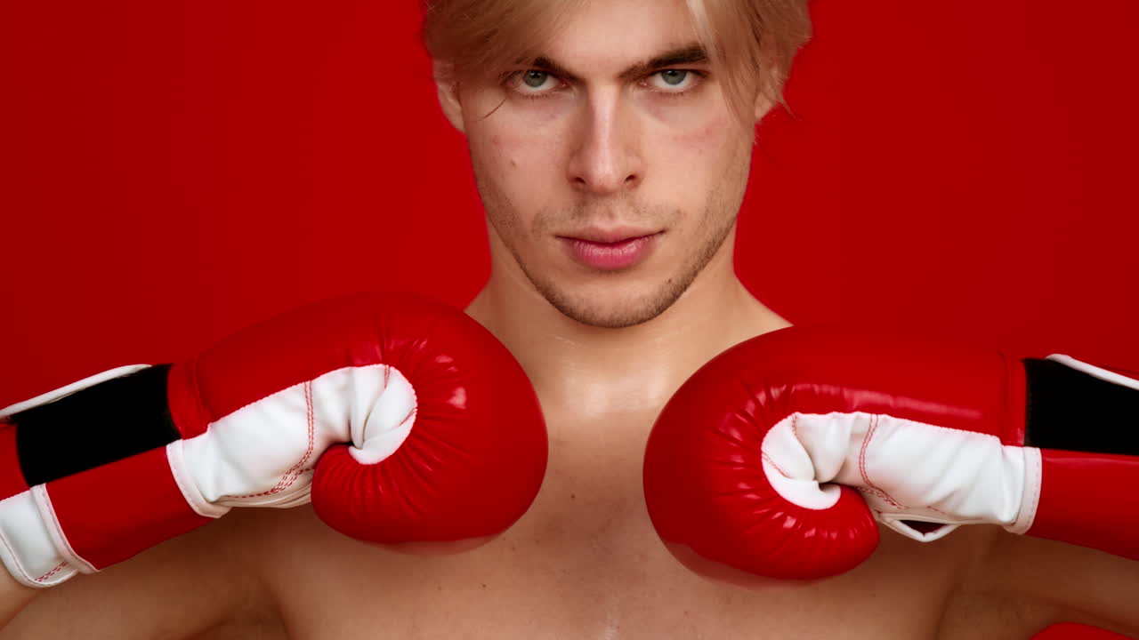 hombre con guantes de boxeo en un estudio rojo