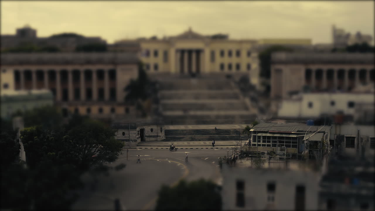 Bus and a red car and pedestrians commuting in a city. Tilt and shift, stop motion, miniature world.