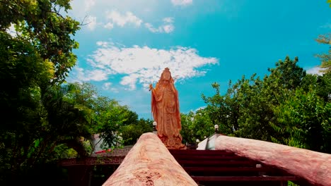 looking up at a large golden kwan im statue at wat samphran temple amhoe sam phran province thailand