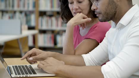 side view of two teachers working at library