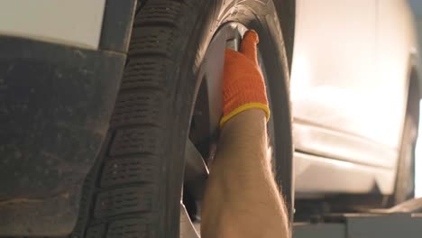 hands of mechanic with tool, changing tyre of car at auto service