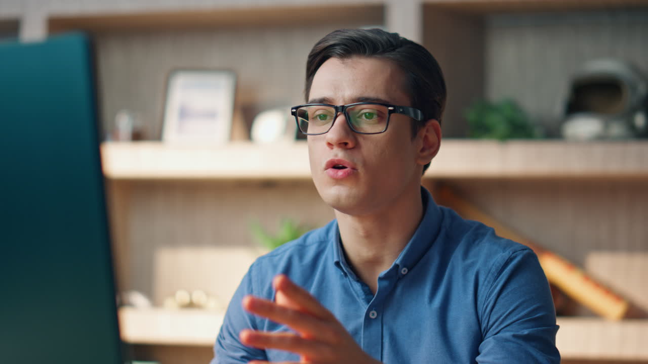 Nervous creator videocalling computer at office. Angry startuper gesturing hands