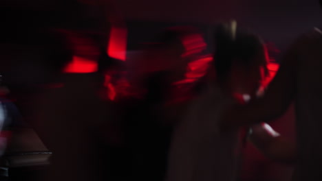 dynamic scene of energetic crowd dancing under vibrant red lights at a lively event atmosphere