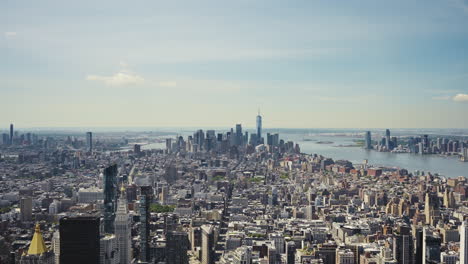 amplia vista panorámica de manhattan con el one world trade center y la estatua de la libertad en la distancia en un día soleado, tiro estático