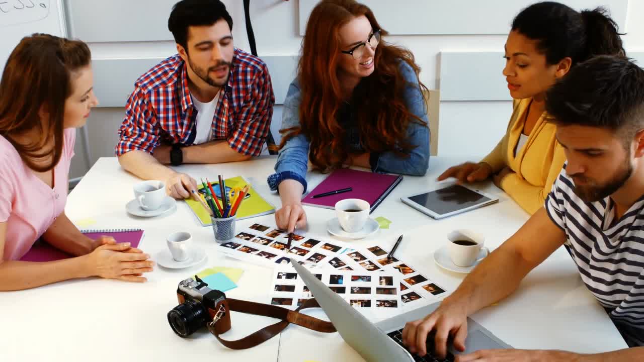 그래픽 디자이너들이 회의 중에 서로 상호 작용하고 있습니다.