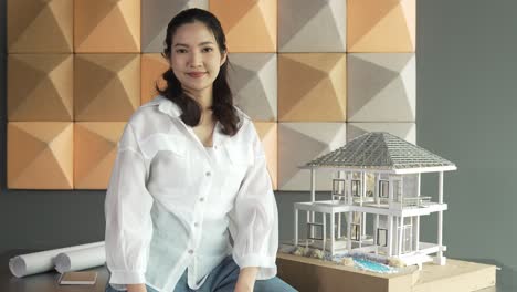 프로 아키텍트가 팔을  ⁇ 고 카메라를 보며 웃고 있습니다. 조작자.