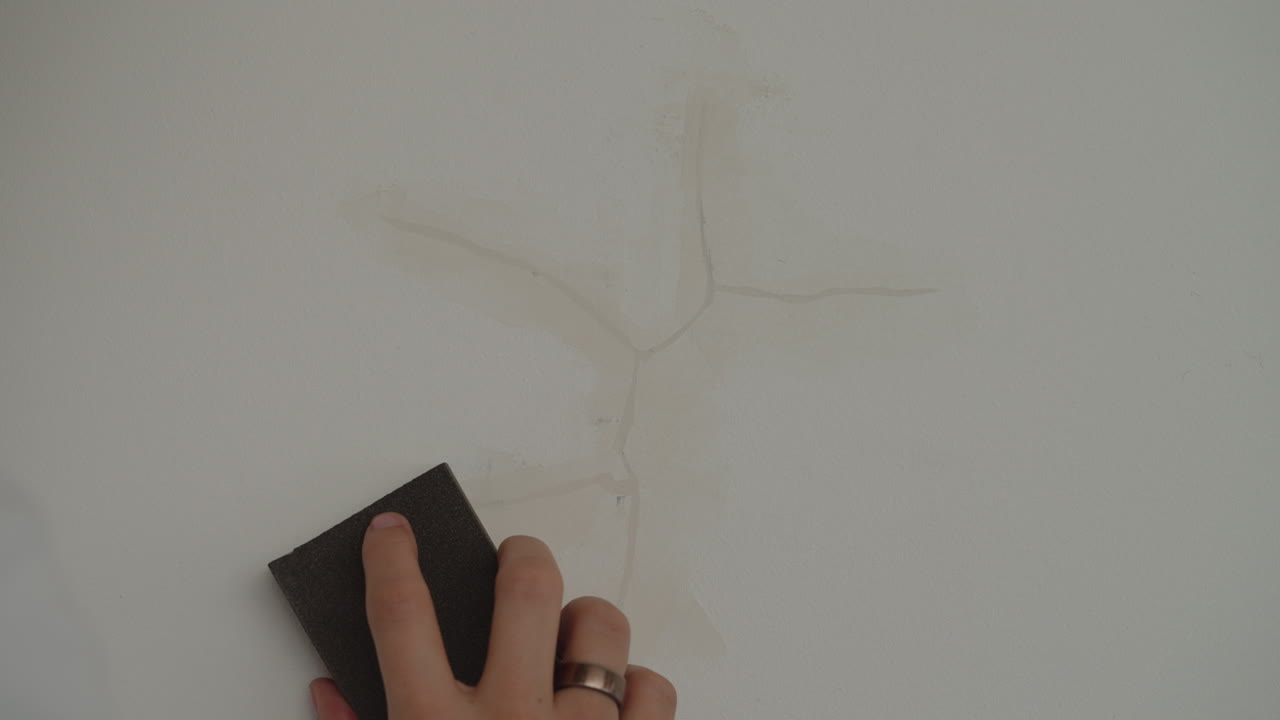 Hand Sanding Cracks On The Wall Using Sanding Sponge. closeup