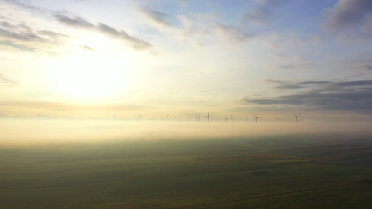 vista lejana de las turbinas eólicas que giran en las nubes contra el cielo soleado y brillante