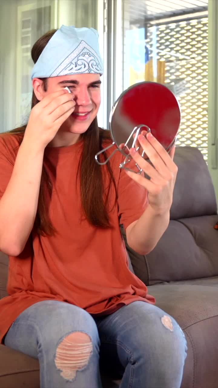 Man applying makeup with mirror
