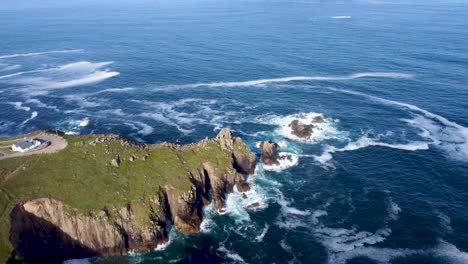 imágenes de drones de 4k de acantilados de lands end con una pequeña isla y olas y un mar azul profundo