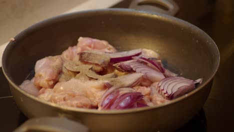 chicken and onions cooking in a pan