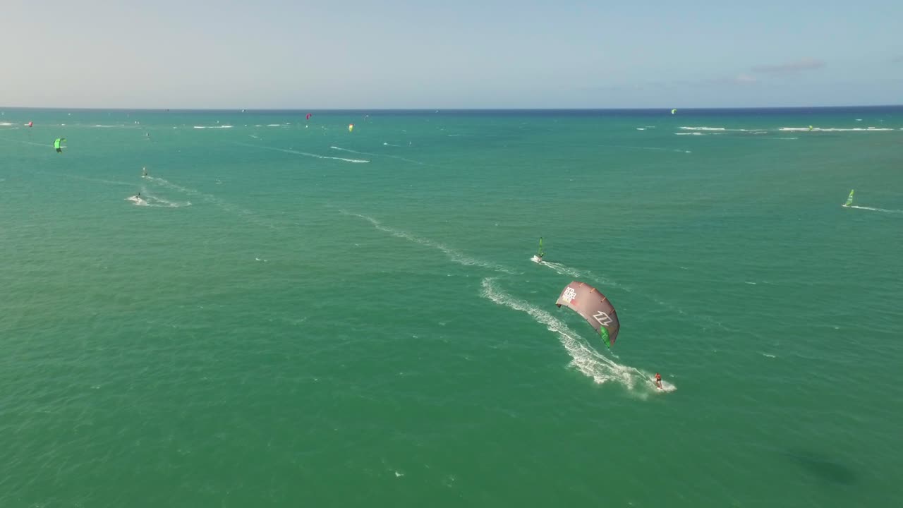vuelo a baja altura viendo las maniobras de los kitesurfistas en la playa