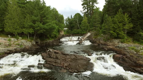 Tilting-Upwards-Establishing-Shot-of-Oxtongue-Waterfalls-at-Algonquin-Park,-Ontario,-Canada