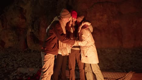 friends enjoying a bonfire in a cave at night.