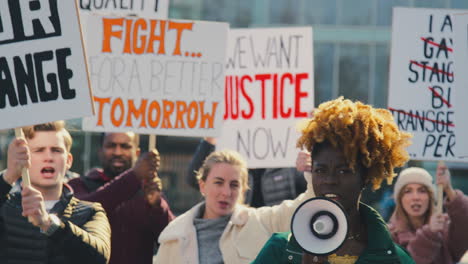 group of protestors with placards and megaphone on demonstration march for gender equality