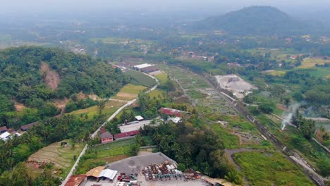 Tropical-landscape-of-Java-and-piles-of-sand-in-processing-site,-aerial-view