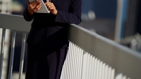 portrait of hispanic businesswoman using tablet on rooftop