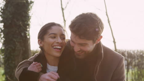 loving young couple hugging on walk through winter countryside together