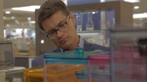 Man-looking-at-plastic-containers-in-the-shop