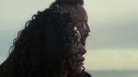 ethnic couple enjoy sunset nature outside. mixed race people face look sea view.