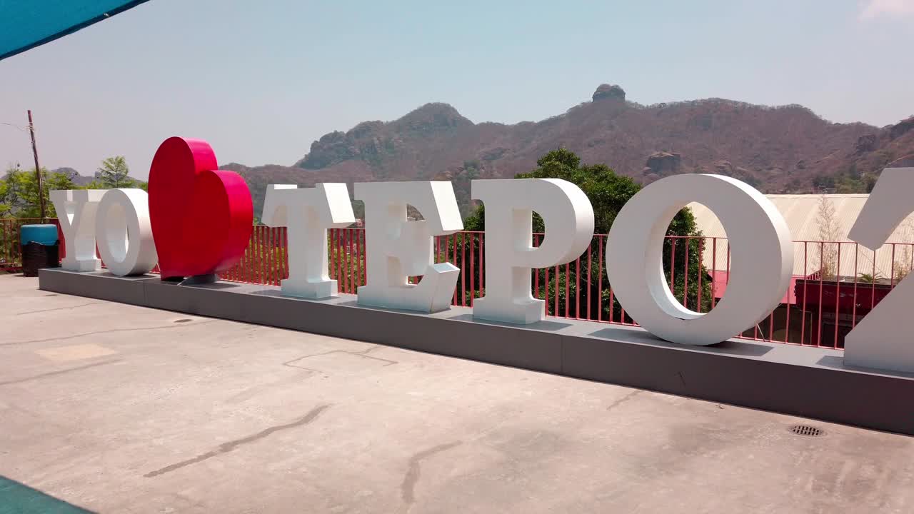 A large "I Love Tepoztlán" sign stands against the backdrop of mountains in Tepoztlán, Morelos