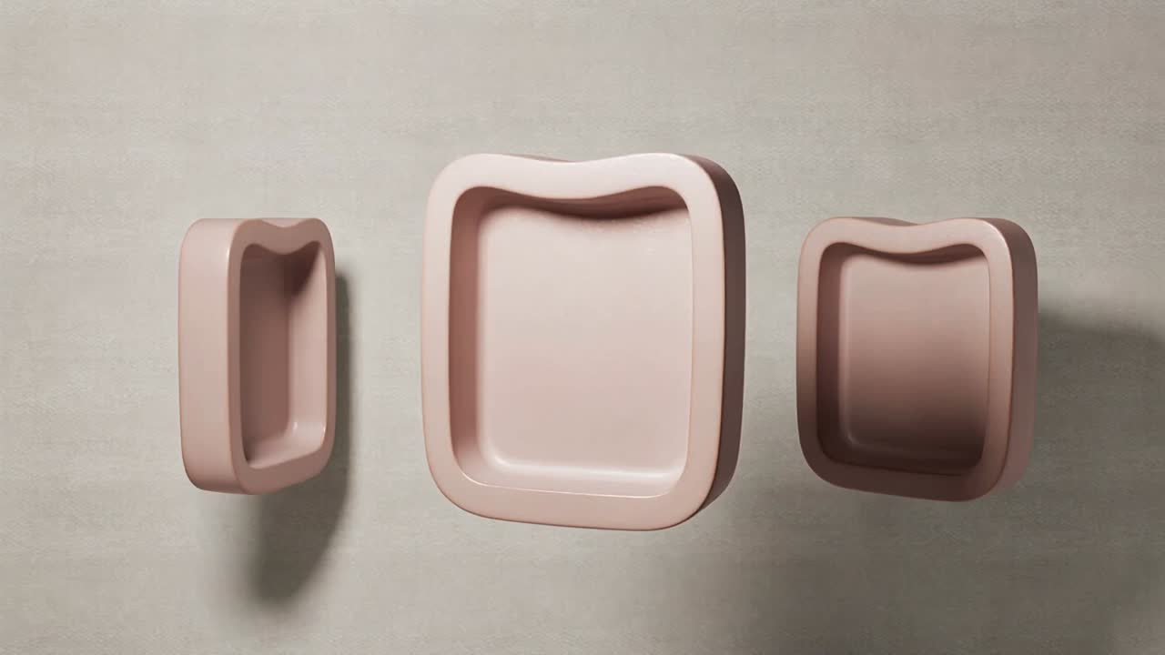 On play, three soft-pink rounded modules rotating, revealing interior on beige wall to show depth