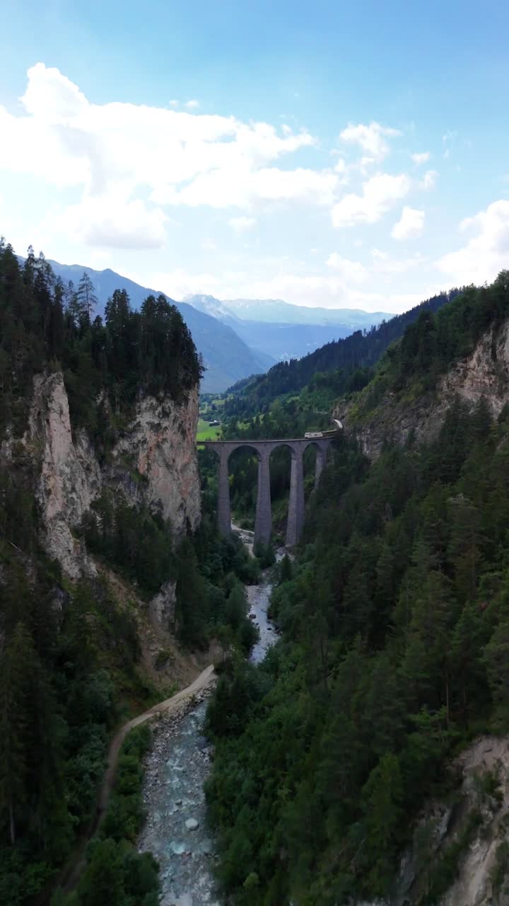 Landwasser Viaduct scenic Swiss train passing ride, aerial drone Switzerland