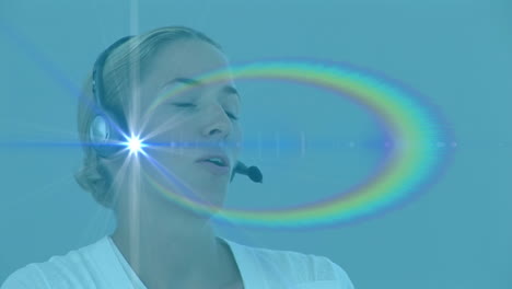 animación de rastros de luz sobre mujer de negocios caucásica usando auriculares de teléfono.