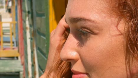 beautiful young caucasian woman standing on beach hut in the sunshine 4k