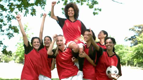 female football team celebrating a win in the park