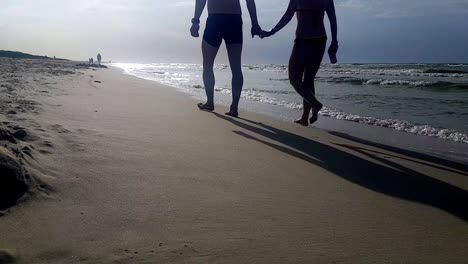 Hombre-Y-Mujer-Caminando-En-La-Playa-De-Arena-Tomados-De-La-Mano