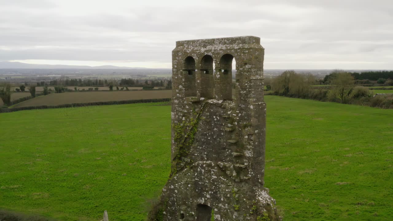 órbita aérea alrededor de la estructura de ladrillo restos de la torre del campanario en la iglesia en el campo verde