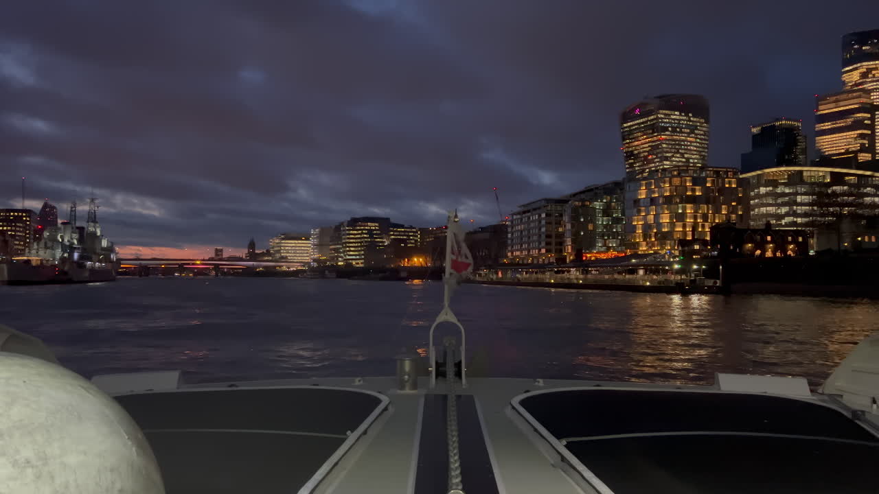 The flag of the United Kingdom waving on a boat moving on the Thames River in the evening in London, England