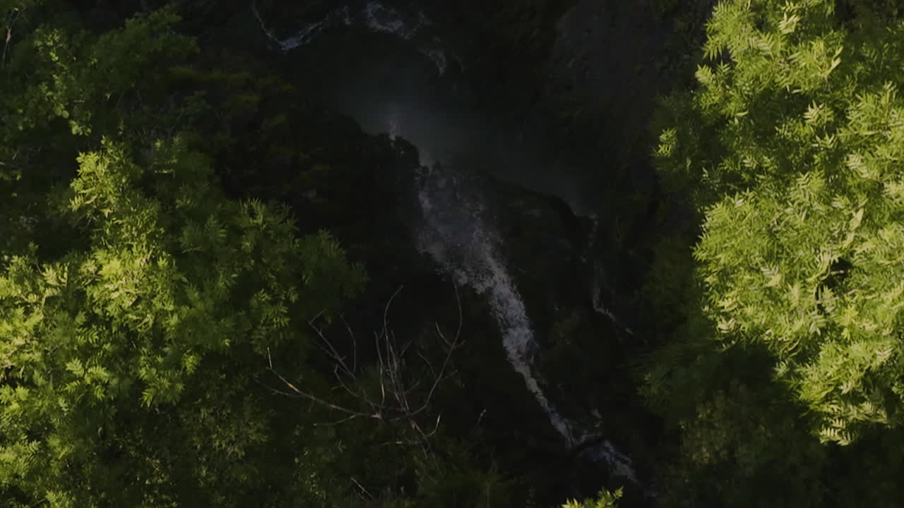 vista superior del denso bosque y el río que cae en cascada en la empinada montaña rocosa en el parque borjomi, georgia