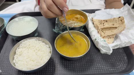 closeup of a women's hand eating food at the hospital after delivering a baby, first meal after delivering a baby