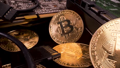 reverse moving macro view of golden bitcoins with a graphics card and hard drive, cryptocurrency mining