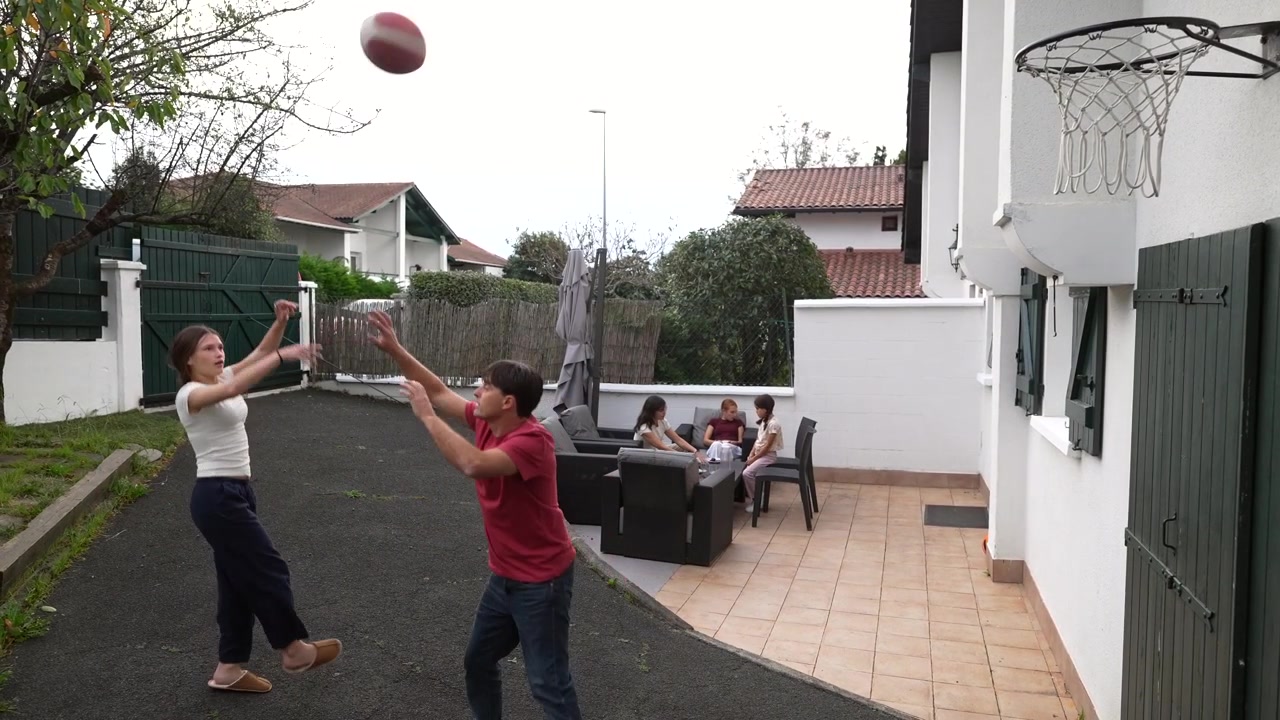 Father and Daughter Playing Basketball in Backyard