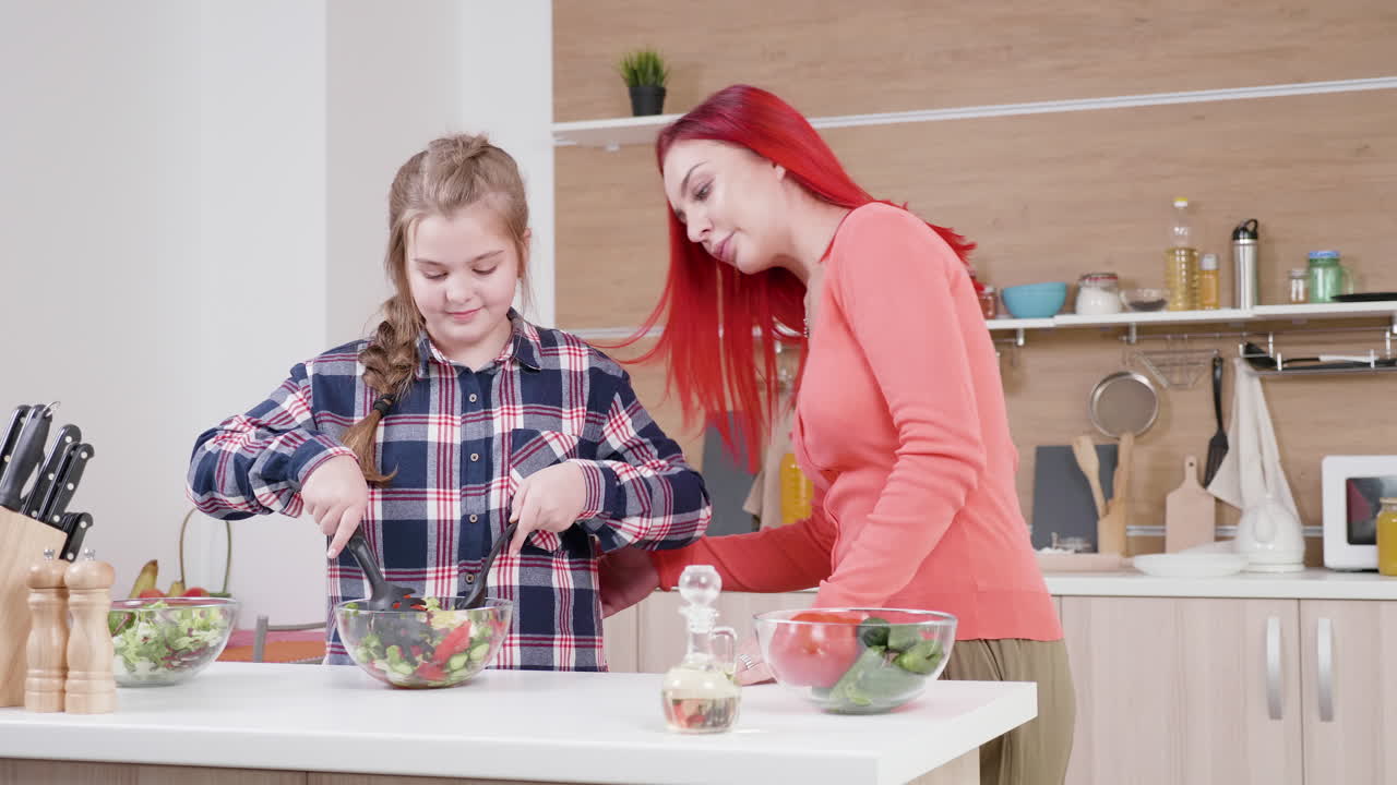 мать и дочь готовят вместе на кухне