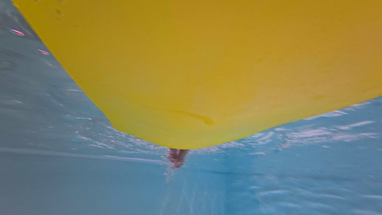 Boy in pool with pineapple, octopus and sunglasses