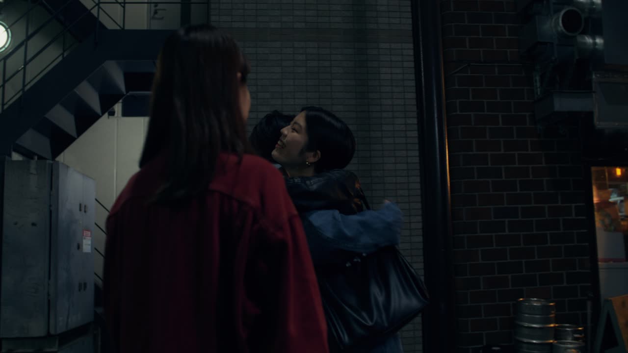 Two People Having Conversation at Night in a City Street