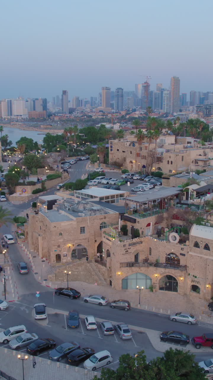 Cloes parallax drone shot of Old city of Jaffa and Jaffa port at sunset - tel aviv city at the background, Vertical video