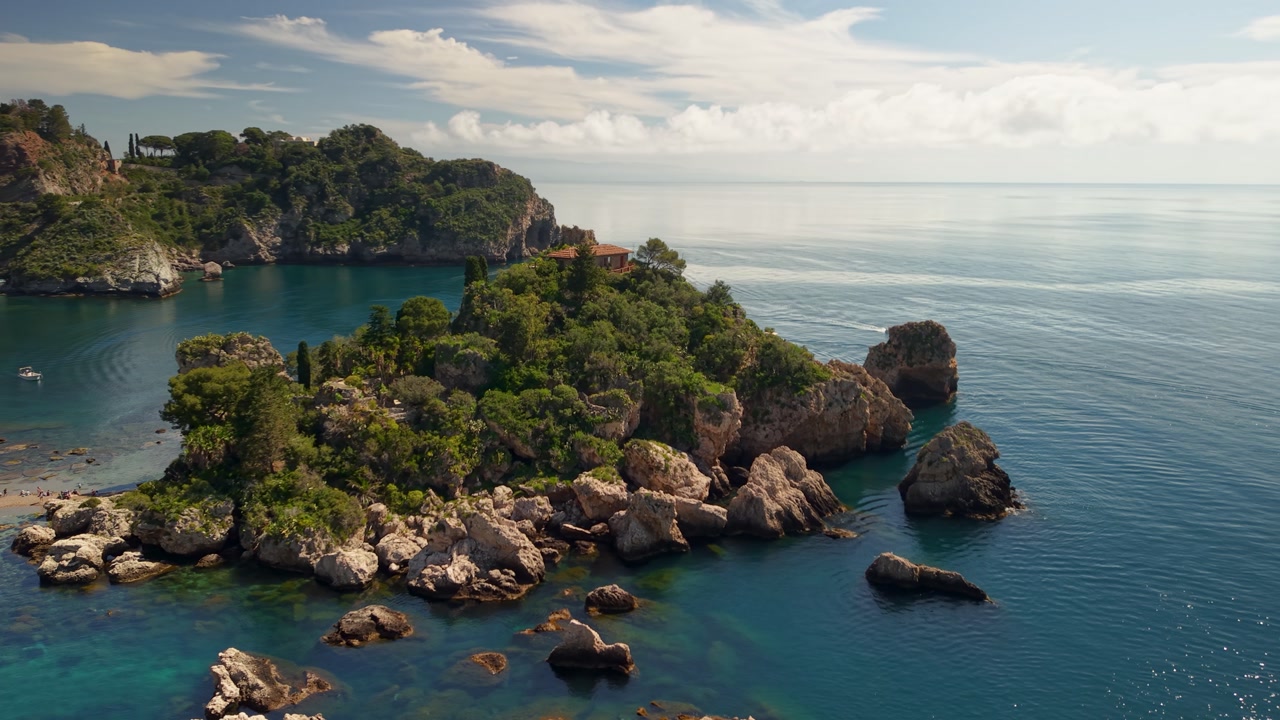 Stunning sunlit Isola Bella island aerial view surrounded by shimmering blue water Italian seascape