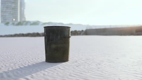 Gray-metal-garbage-bin-or-trash-can-on-the-beach