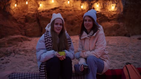 two women enjoying a cozy evening at the beach